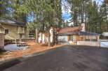 Nestled among tall pine trees, this charming property offers a serene retreat.