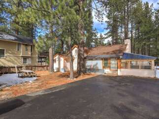 Nestled among tall pine trees, this charming property offers a serene retreat.