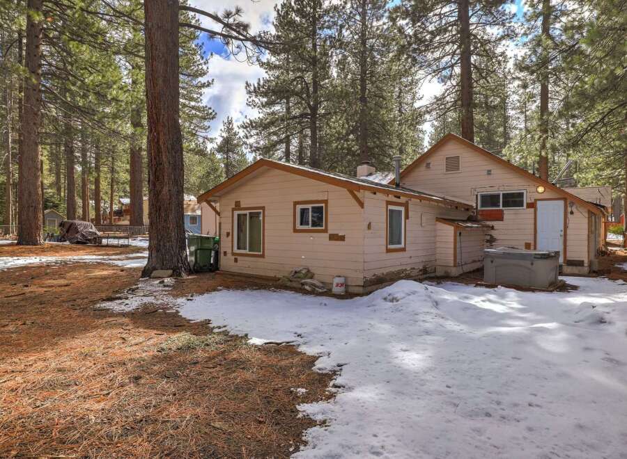 Nestled among tall pine trees, this charming property offers a serene retreat with a private hot tub perfect for relaxation.