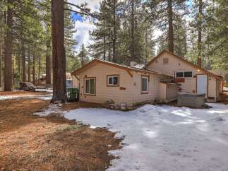 Nestled among tall pine trees, this charming property offers a serene retreat with a private hot tub perfect for relaxation.