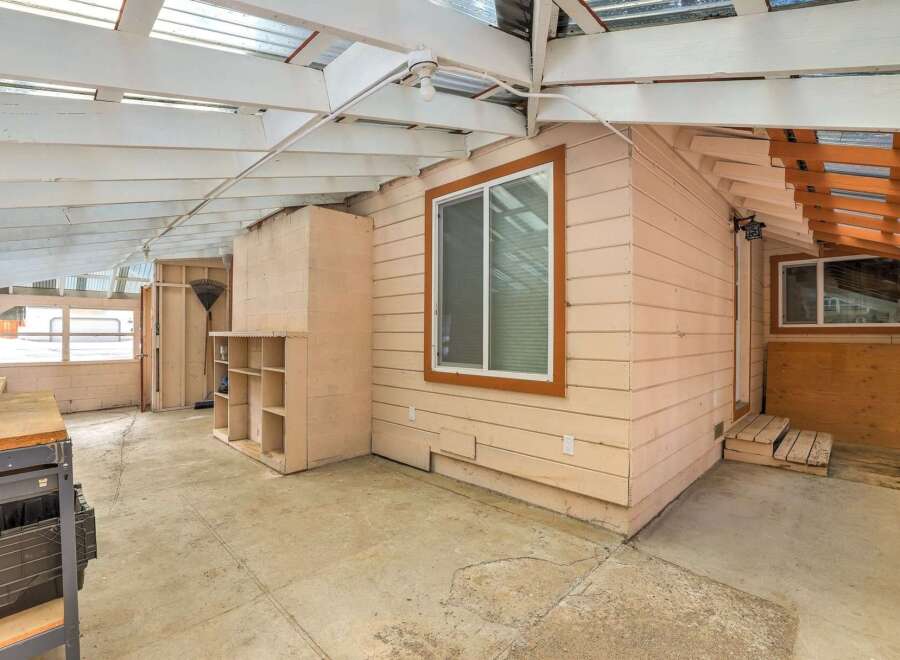Discover a versatile sunroom or workshop space with ample natural light filtering through the clear roof panels.