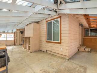 Discover a versatile sunroom or workshop space with ample natural light filtering through the clear roof panels.