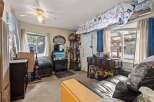 Cozy living room featuring a fireplace, a ceiling fan, and ample storage solutions.