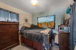 Discover a cozy bedroom featuring a comfortable bed adorned with a plush grey blanket and decorative pillows.