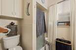 This charming bathroom features a functional toilet with a decorative storage cabinet and a wall-mounted toilet paper holder.