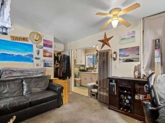 Discover a cozy living space featuring a comfortable black leather sofa perfect for relaxation.
