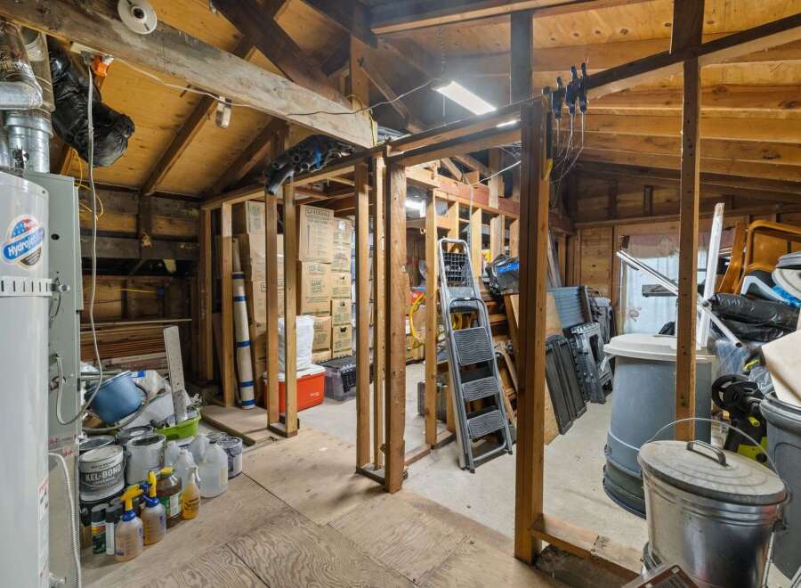 This spacious storage area offers ample room for all your belongings, featuring a water heater and a variety of paint and cleaning supplies.