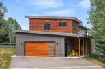 Discover modern living in this stunning home featuring a striking combination of warm wood and sleek gray siding.