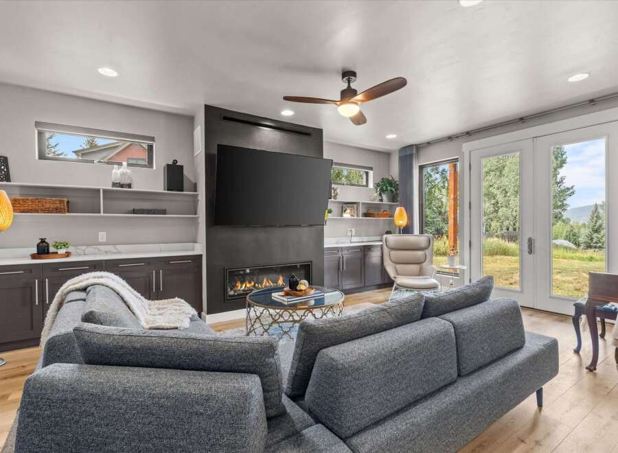Experience modern living in this stunning living room, featuring a sleek fireplace and a large flat-screen TV.