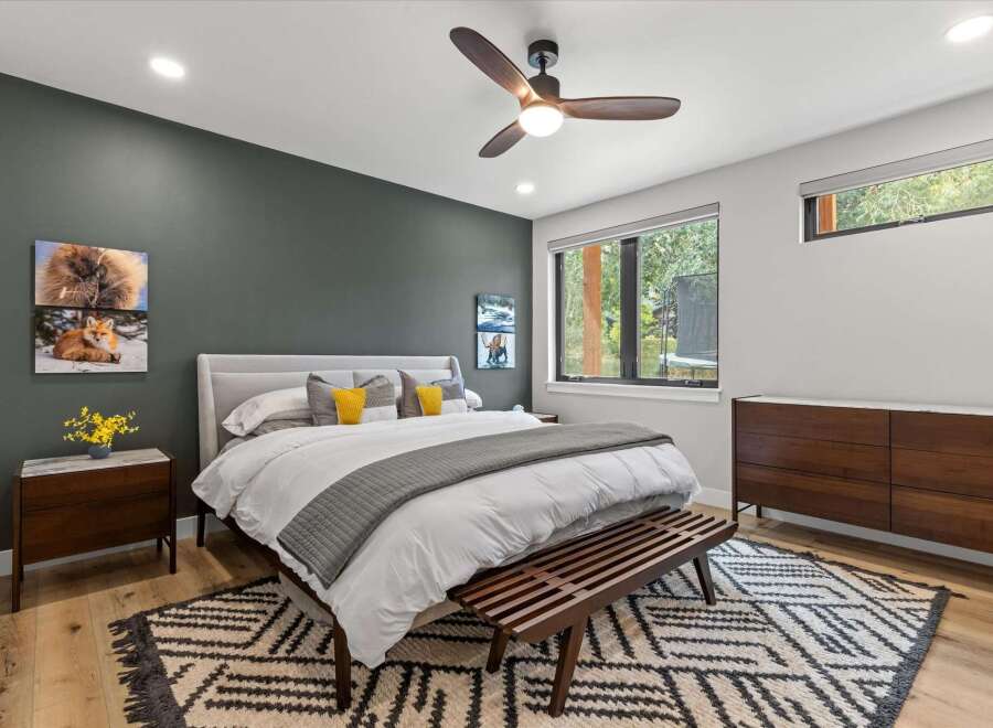 Experience modern comfort in this beautifully appointed bedroom, featuring a plush king-sized bed with crisp white linens and accent pillows.