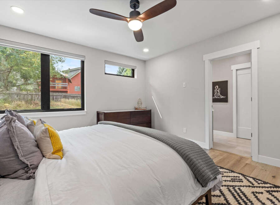 This modern bedroom features a large window offering scenic views of the outdoors.