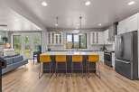 Experience modern living in this stunning open-concept kitchen, featuring a large island with vibrant yellow bar stools perfect for casual dining or entertaining.
