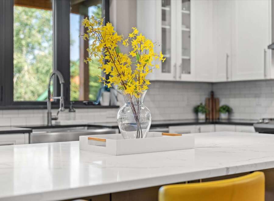 Experience modern luxury in this stunning kitchen, featuring a sleek quartz countertop island perfect for entertaining.