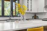 Experience modern luxury in this stunning kitchen, featuring a sleek quartz countertop island perfect for entertaining.
