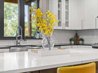 Experience modern luxury in this stunning kitchen, featuring a sleek quartz countertop island perfect for entertaining.