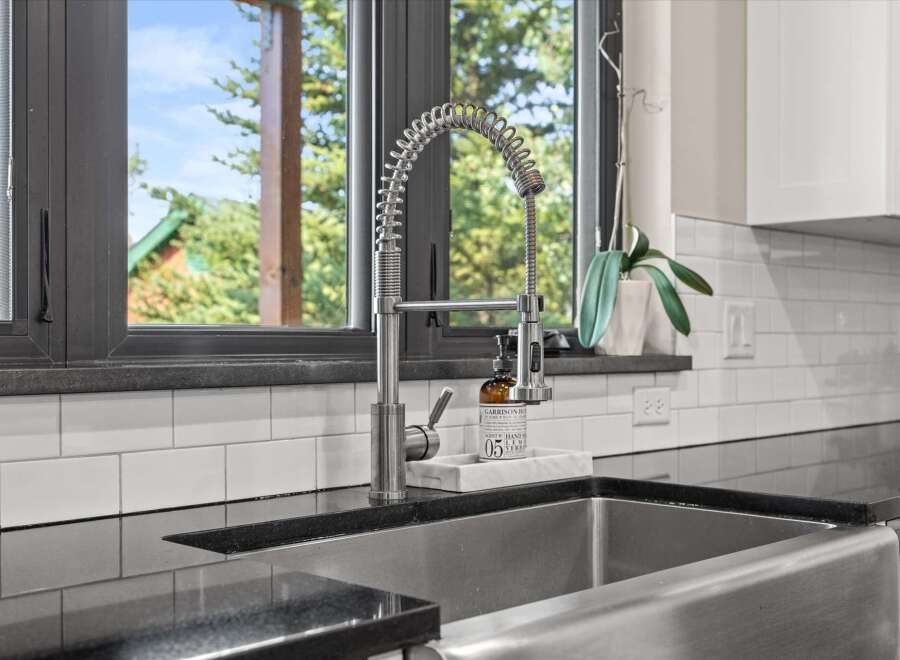 Experience modern kitchen luxury with this stunning farmhouse sink and sleek faucet.