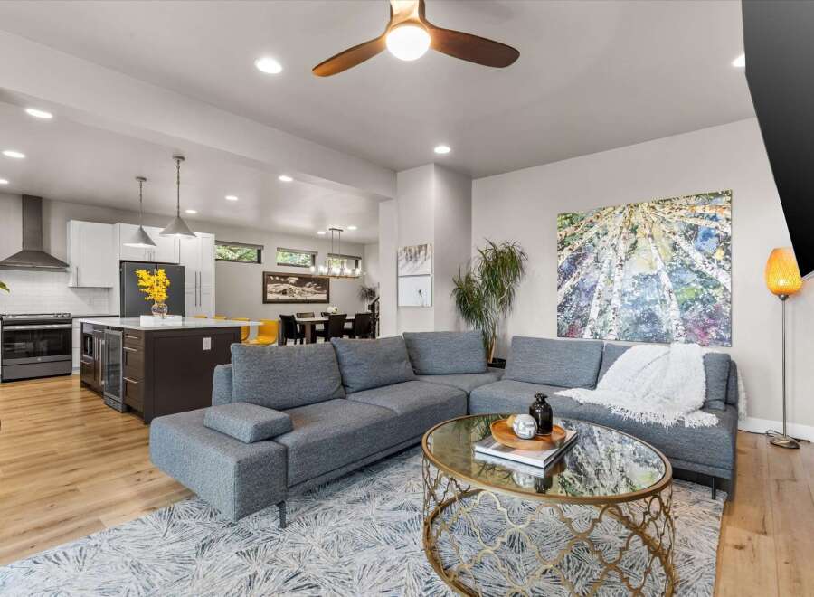 Experience modern open-concept living in this stunning home, featuring a sleek kitchen with a central island and a spacious living area perfect for entertaining.