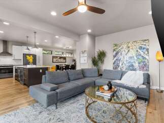 Experience modern open-concept living in this stunning home, featuring a sleek kitchen with a central island and a spacious living area perfect for entertaining.