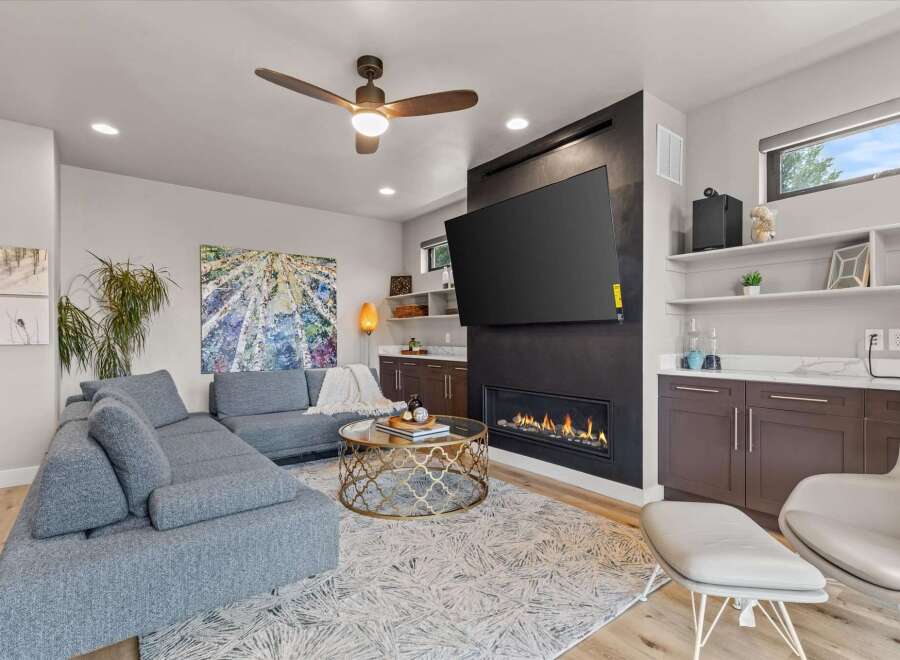Experience modern living in this stylish living room, featuring a sleek gas fireplace as the centerpiece and a large flat-screen TV mounted above.