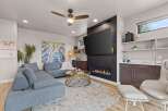 Experience modern living in this stylish living room, featuring a sleek gas fireplace as the centerpiece and a large flat-screen TV mounted above.