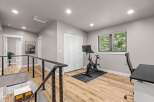 This modern home features a dedicated home gym space with a Peloton bike and a comfortable office chair, perfect for staying active and productive.