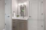 This modern bathroom features a sleek vanity with ample storage and a clean white countertop.