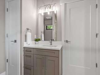 This modern bathroom features a sleek vanity with ample storage and a clean white countertop.