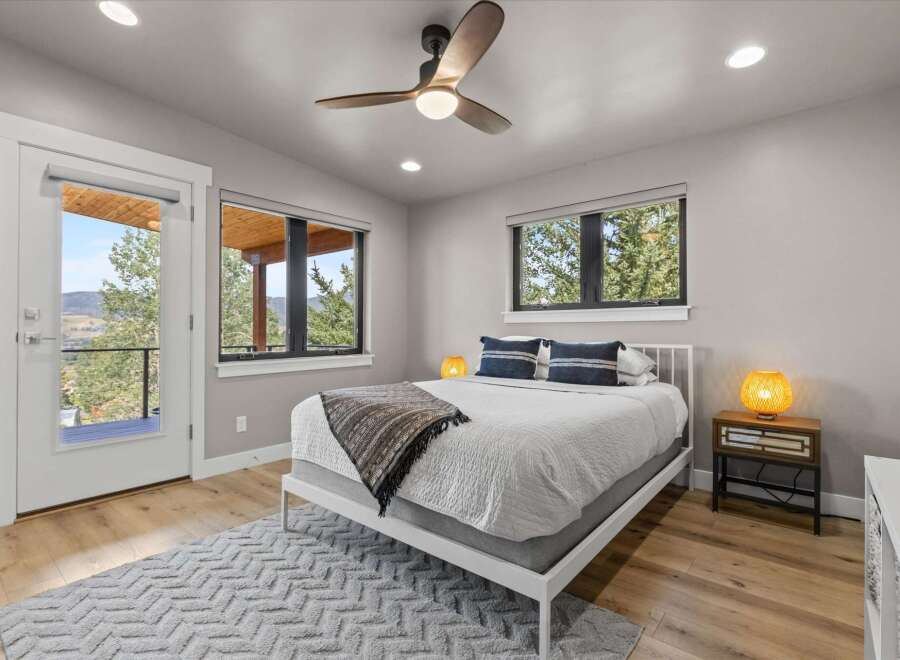 Experience mountain living in this charming bedroom featuring a comfortable queen-size bed adorned with decorative pillows and a cozy throw blanket.