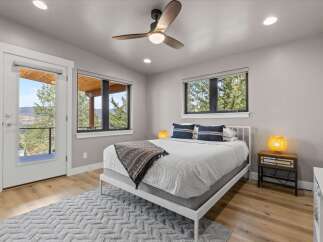 Experience mountain living in this charming bedroom featuring a comfortable queen-size bed adorned with decorative pillows and a cozy throw blanket.