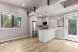Experience modern living in this stylish apartment featuring a sleek, open-concept kitchen with a central island and stainless steel appliances.