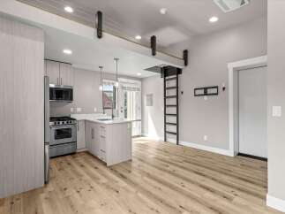 Discover modern living in this stylish studio apartment featuring a sleek, contemporary kitchen with stainless steel appliances and a convenient island.