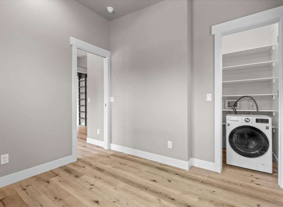 Discover modern convenience in this home featuring a dedicated laundry closet equipped with a sleek, front-loading washing machine.