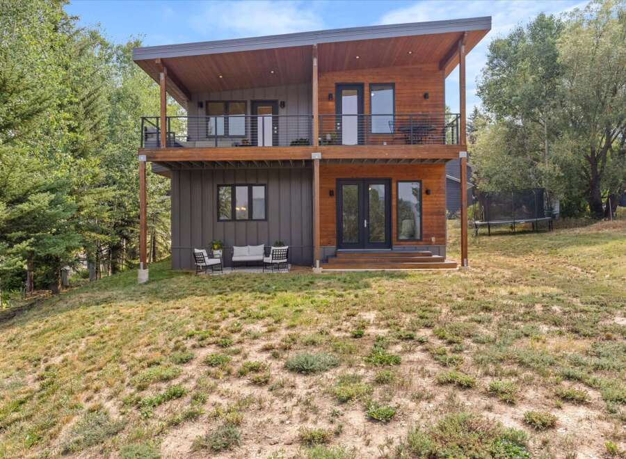 Discover modern living in this stunning two-story home, featuring a striking combination of wood and dark siding.