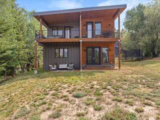 Discover modern living in this stunning two-story home, featuring a striking combination of wood and dark siding.