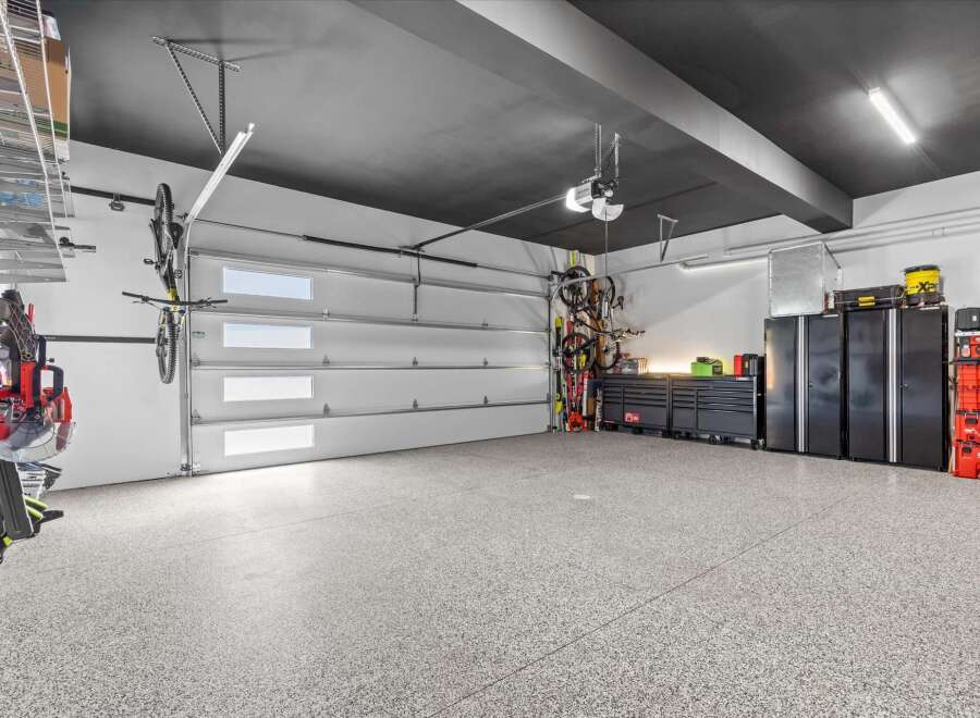 This spacious garage features a sleek, modern design with a dark ceiling and durable epoxy flooring.