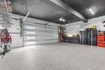 This spacious garage features a sleek, modern design with a dark ceiling and durable epoxy flooring.