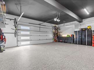 This spacious garage features a sleek, modern design with a dark ceiling and durable epoxy flooring.