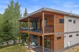 Experience modern living in this stunning multi-level home, featuring a striking combination of warm wood siding and sleek gray panels.