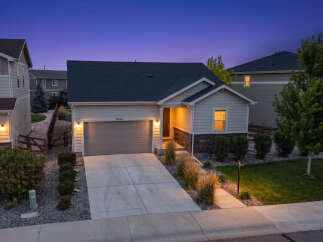 This charming single-family home features a welcoming facade with a well-maintained lawn and landscaping.