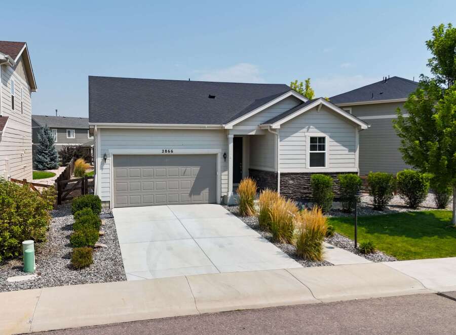 Discover this charming single-family home featuring a modern gray garage door and a welcoming light-colored exterior.
