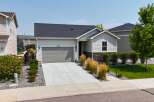 Discover this charming single-family home featuring a modern gray garage door and a welcoming light-colored exterior.