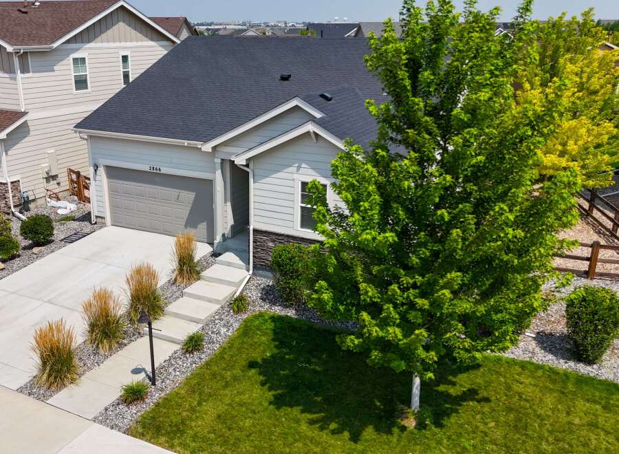 Discover this charming single-family home featuring a spacious two-car garage and a welcoming front entrance with a paved walkway.