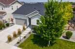 Discover this charming single-family home featuring a spacious two-car garage and a welcoming front entrance with a paved walkway.