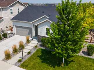 Discover this charming single-family home featuring a spacious two-car garage and a welcoming front entrance with a paved walkway.