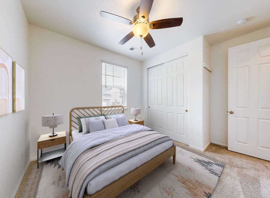 This inviting bedroom features a comfortable queen-size bed with a stylish wooden headboard, complemented by two matching nightstands and lamps.