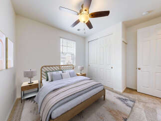 This inviting bedroom features a comfortable queen-size bed with a stylish wooden headboard, complemented by two matching nightstands and lamps.