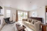Experience modern living in this spacious living room, featuring a plush sectional sofa perfect for relaxation and entertaining.