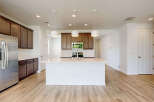 This spacious kitchen boasts modern stainless steel appliances, including a refrigerator and a gas range.
