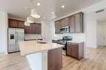 Experience modern living in this stunning kitchen featuring a spacious island with a built-in sink and elegant pendant lighting.