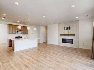 Experience modern living in this open-concept home featuring a sleek kitchen with rich wood cabinetry and a spacious island.